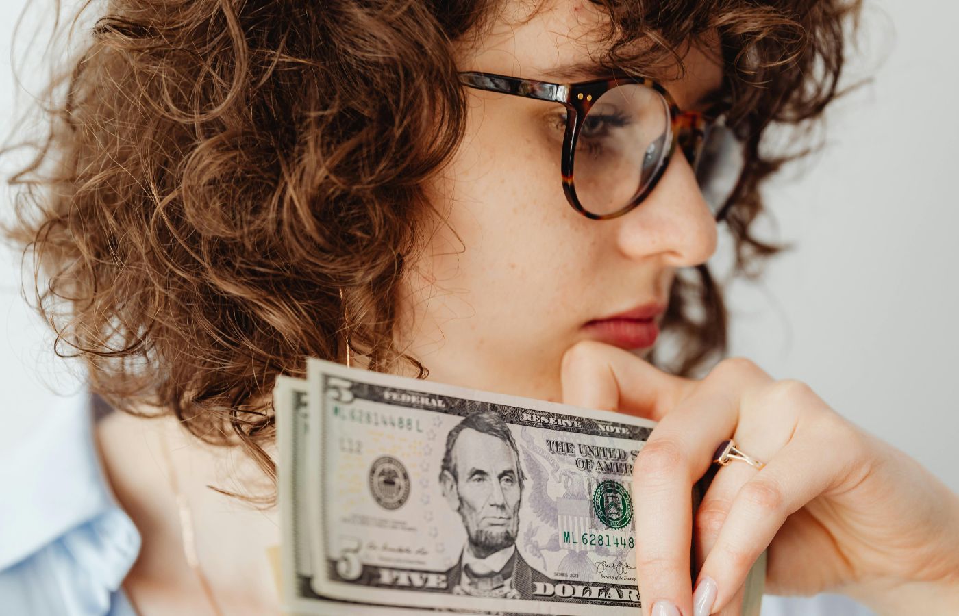 A Woman Wearing Eyeglasses Holding Money