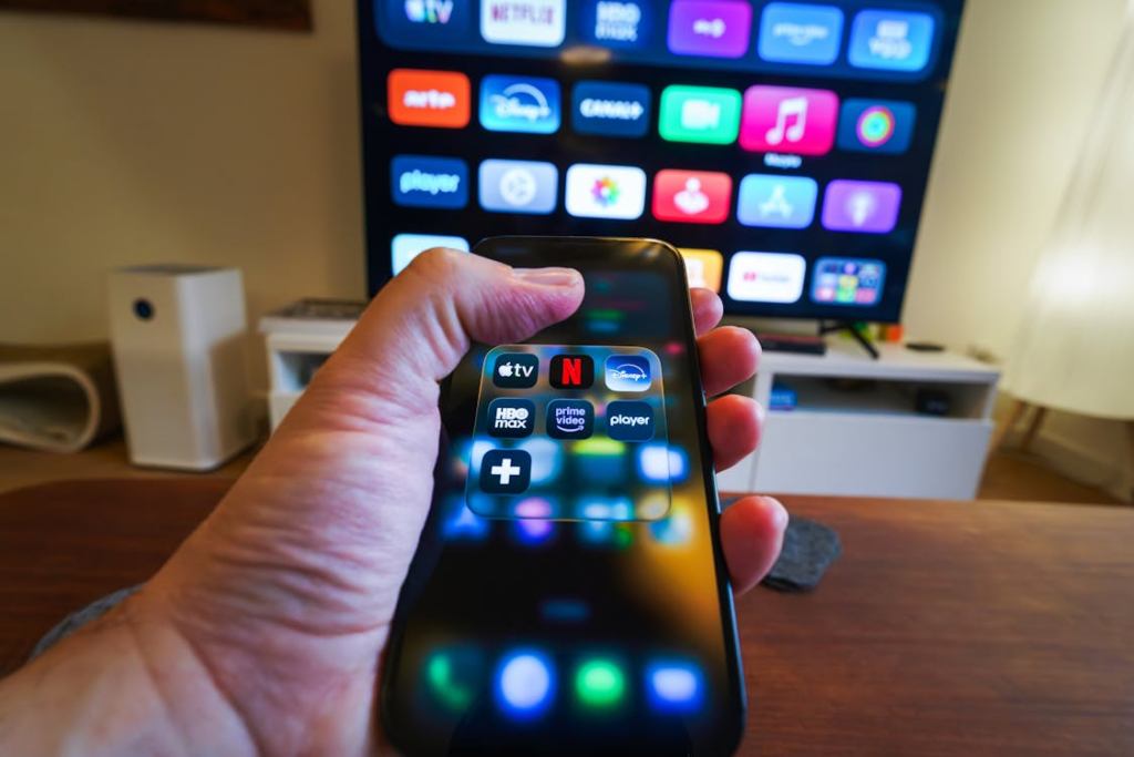 Phone showing streaming apps while comparing are carrier streaming bundles worth it for home entertainment.