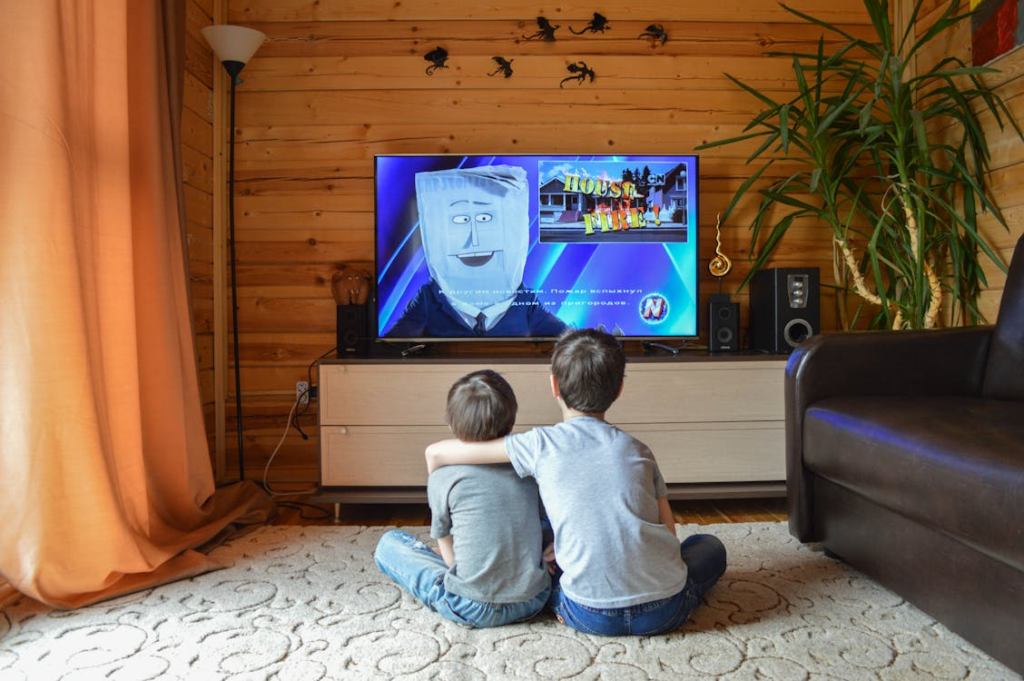Children watching TV at home using one of the best streaming services for kids.