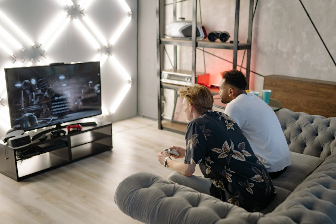 Two people gaming at home with the best internet for streaming and gaming on a large TV setup.