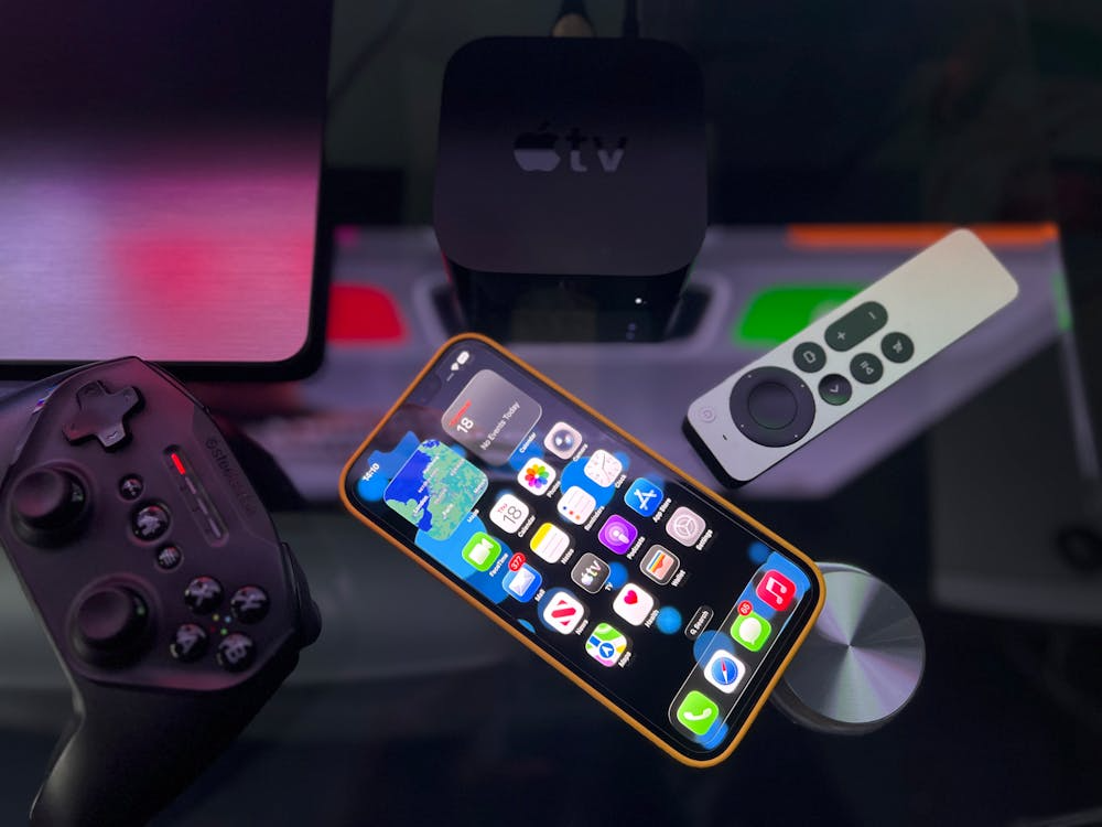 Best streaming device setup with Apple TV, smart remote, smartphone, and game controller.