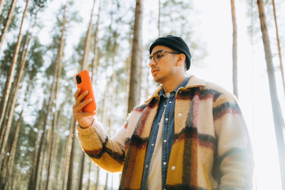 Person checking phone signal outdoors while comparing the best phone plans for rural areas.